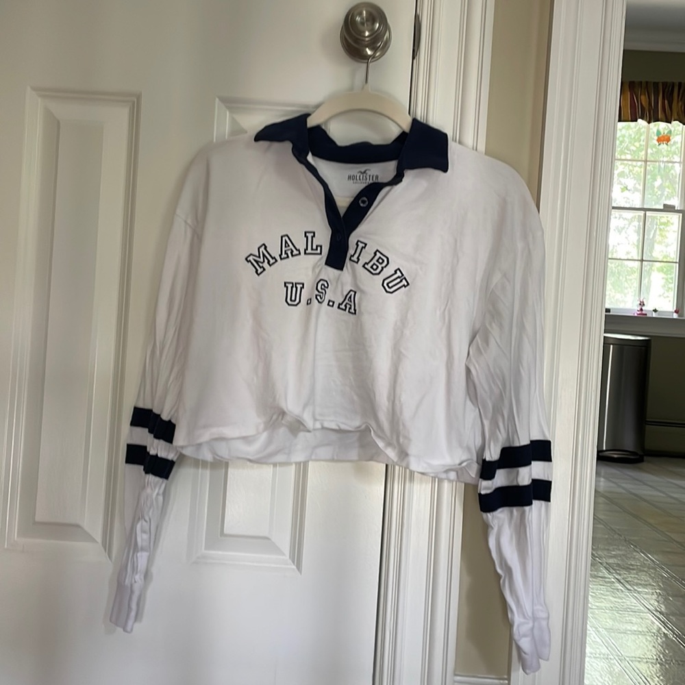Brand is Hollister. It’s navy blue and white. Size is small. A bit cropped.